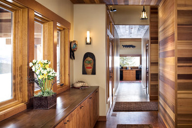 Ispirazione per un ingresso o corridoio contemporaneo di medie dimensioni con pareti beige, pavimento in legno massello medio e pavimento marrone