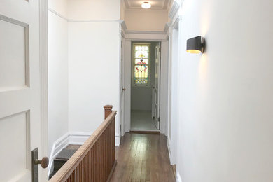 Imagen de recibidores y pasillos clásicos de tamaño medio con paredes blancas, suelo de madera en tonos medios y suelo marrón