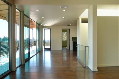 Diseño de recibidores y pasillos contemporáneos de tamaño medio con paredes beige y suelo de madera en tonos medios