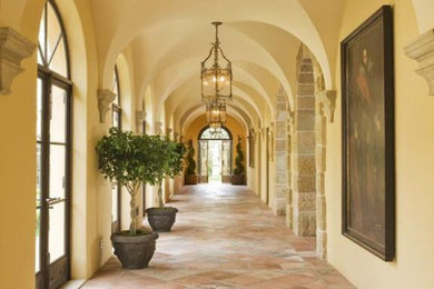 Imagen de recibidores y pasillos mediterráneos con paredes beige y suelo de baldosas de terracota