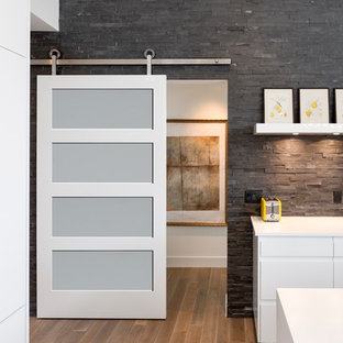 Réalisation d'un couloir design de taille moyenne avec un mur noir, un sol en bois brun et un sol marron.