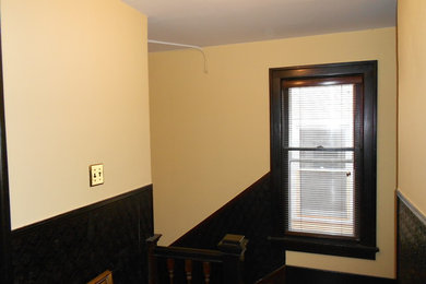 Example of a large dark wood floor hallway design in Detroit with yellow walls