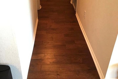Hallway - mid-sized dark wood floor hallway idea in Dallas with white walls