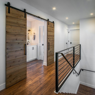 Idee per un ingresso o corridoio di medie dimensioni con pareti bianche, pavimento in laminato e pavimento marrone