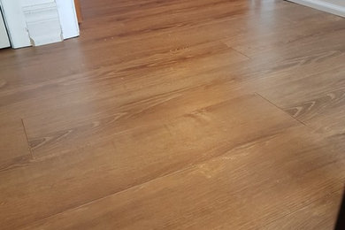 Example of a mid-sized trendy medium tone wood floor and brown floor hallway design in Toronto with white walls