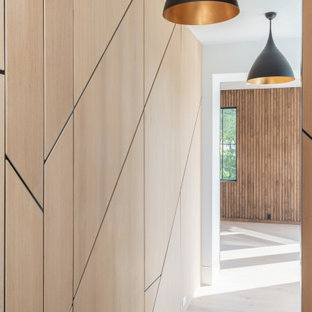 Modern inredning av en stor hall, med beige väggar, ljust trägolv och beiget golv