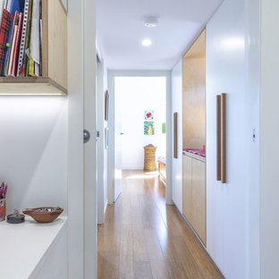 Ispirazione per un piccolo ingresso o corridoio minimal con pareti bianche, pavimento in bambù e pavimento marrone