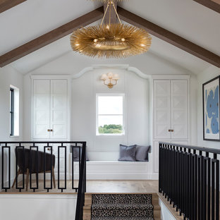 Mediterranean hallway in Minneapolis with white walls, light hardwood floors and beige floor.