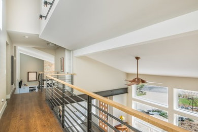 Trendy medium tone wood floor hallway photo in Denver with beige walls