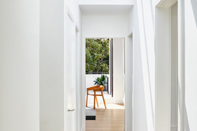 На фото: узкий коридор среднего размера в современном стиле с светлым паркетным полом с