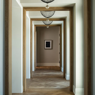 Foto di un grande ingresso o corridoio eclettico con pareti beige, pavimento in legno massello medio e pavimento marrone