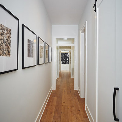 Large cottage medium tone wood floor hallway photo in Grand Rapids with gray walls
