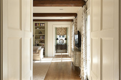 Mid-sized elegant medium tone wood floor hallway photo in Dallas with white walls