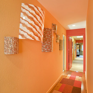 Inspiration för moderna hallar, med orange väggar, mellanmörkt trägolv och orange golv