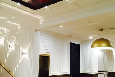 ヒューストンにあるラグジュアリーな広いトランジショナルスタイルのおしゃれな廊下 (白い壁、ライムストーンの床) の写真