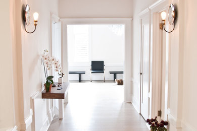 Mid-sized transitional light wood floor hallway photo in San Francisco with white walls