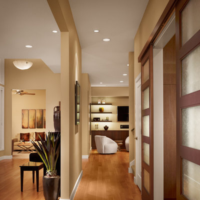 Mid-sized trendy medium tone wood floor and brown floor hallway photo in Austin with beige walls