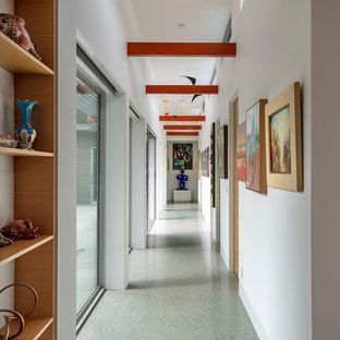 Inspiration pour un couloir vintage avec un mur blanc, un sol gris et un plafond en poutres apparentes.