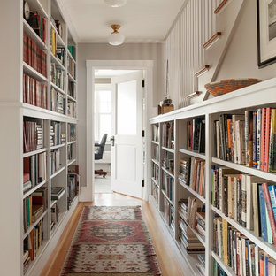 This is an example of a beach style hallway in Portland Maine with white walls and medium hardwood floors.