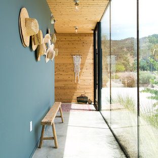 Ispirazione per un ingresso o corridoio country con pareti blu, pavimento in cemento e pavimento grigio