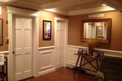 Elegant medium tone wood floor and brown floor hallway photo in New York with multicolored walls