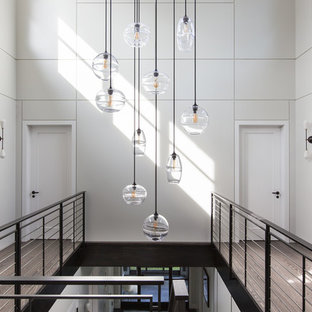 Exemple d'un couloir tendance avec un mur gris, un sol en bois clair et un sol beige.