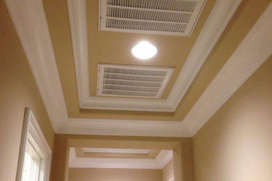 Hallway - large dark wood floor hallway idea in Las Vegas with beige walls