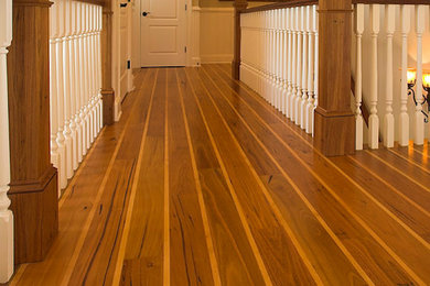 Transitional medium tone wood floor hallway photo in Raleigh with white walls