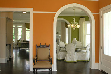 Hallway - mid-sized transitional dark wood floor hallway idea in Miami with orange walls
