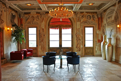 Huge tuscan beige floor and limestone floor hallway photo in Los Angeles with multicolored walls