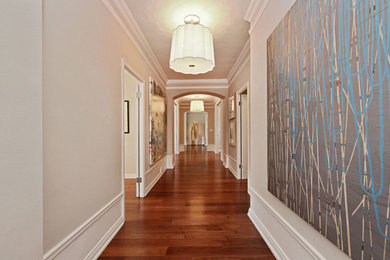 Cette photo montre un couloir chic avec un mur beige et parquet foncé.
