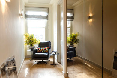 Cette photo montre un couloir chic de taille moyenne avec un mur gris, parquet clair et un sol beige.