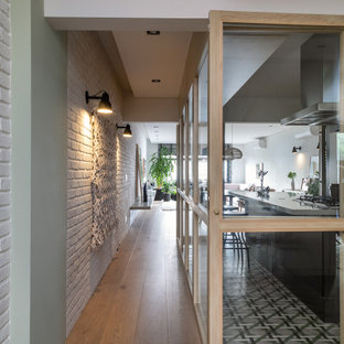 Inspiration för mellanstora moderna hallar, med vita väggar, ljust trägolv och beiget golv