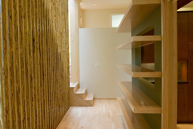 Modelo de recibidores y pasillos modernos de tamaño medio con paredes beige y suelo de madera clara