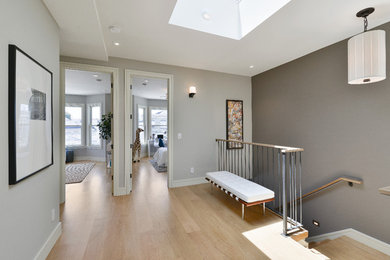 Diseño de recibidores y pasillos contemporáneos de tamaño medio con paredes grises, suelo de madera clara y suelo beige