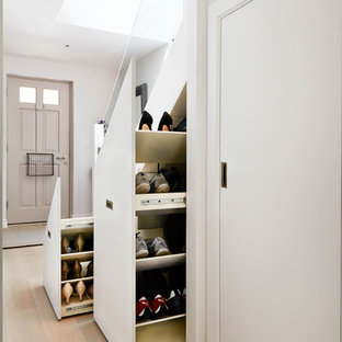 Esempio di un ingresso o corridoio minimal con pareti grigie e parquet chiaro