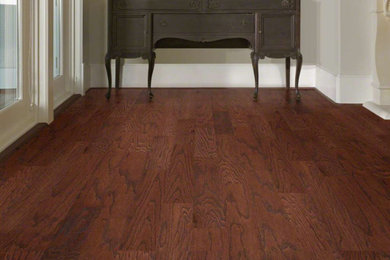 Example of a large classic dark wood floor and brown floor hallway design in Phoenix with gray walls