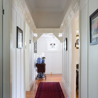 Inspiration for a beach style hallway in Brisbane with white walls, medium hardwood floors and brown floor.