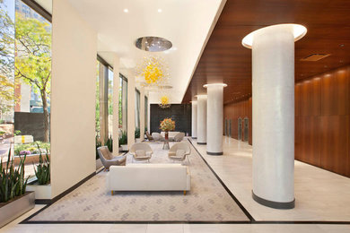 Foto de recibidores y pasillos contemporáneos extra grandes con paredes beige y suelo de mármol