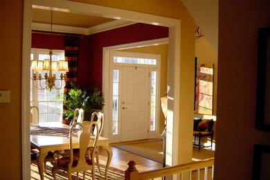 Foto de recibidores y pasillos clásicos de tamaño medio con paredes rojas y suelo de madera clara