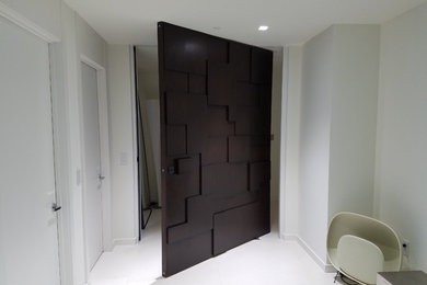 Example of a mid-sized minimalist porcelain tile and white floor hallway design in Miami with white walls