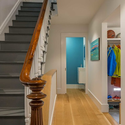 Hallway - mid-sized transitional medium tone wood floor hallway idea in Boston with white walls