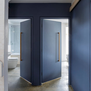 Foto di un ingresso o corridoio minimal di medie dimensioni con pareti blu e pavimento in cemento