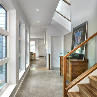Modern inredning av en mellanstor hall, med grått golv, grå väggar och betonggolv
