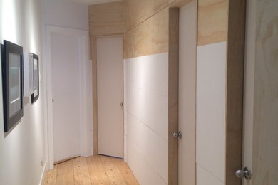 Hallway - scandinavian plywood floor hallway idea in Toronto