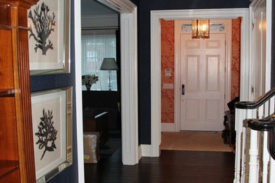 Imagen de recibidores y pasillos clásicos pequeños con paredes azules, suelo de madera oscura y iluminación