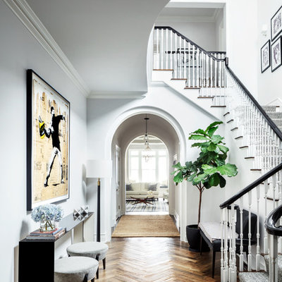 Example of a classic medium tone wood floor and brown floor hallway design in New York with white walls