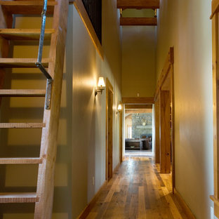 Inspiration pour un couloir chalet avec un mur beige, un sol en bois brun et un sol jaune.