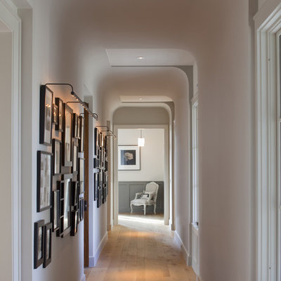 Example of a classic medium tone wood floor hallway design in Austin with white walls