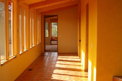 Ejemplo de recibidores y pasillos de estilo americano de tamaño medio con suelo de baldosas de terracota